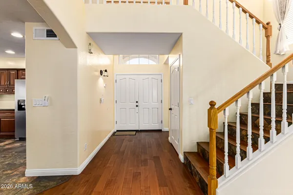 a view of a hallway with wooden floor and staircase