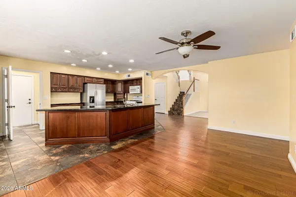 a kitchen with stainless steel appliances granite countertop a refrigerator a stove and a sink with wooden cabinets