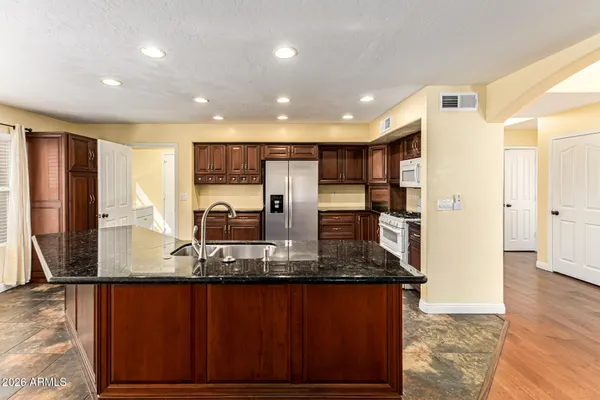 a large kitchen with stainless steel appliances granite countertop a large center island and a stove
