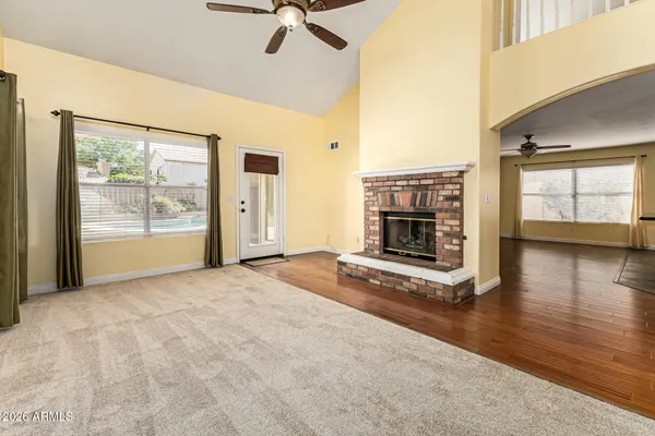 a view of an empty room with a fireplace and a window