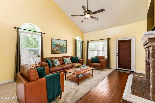 a living room with furniture ceiling fan and a wooden floor