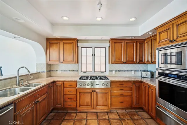 a kitchen with stainless steel appliances granite countertop a stove sink and cabinets
