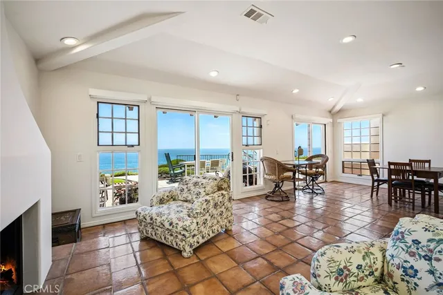 a living room with furniture and a dining table with large windows