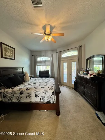 a bedroom with a large bed and a chandelier