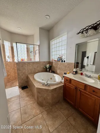 a bathroom with a granite countertop sink mirror bathtub and toilet