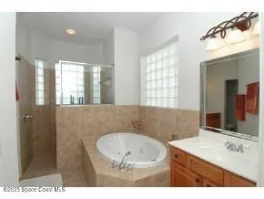 a bathroom with a bathtub a sink and a mirror
