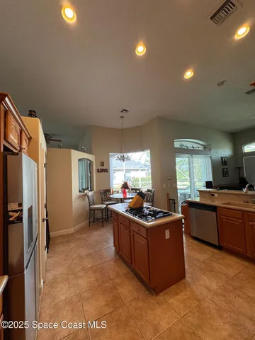 a living room with furniture a flat screen tv and a refrigerator