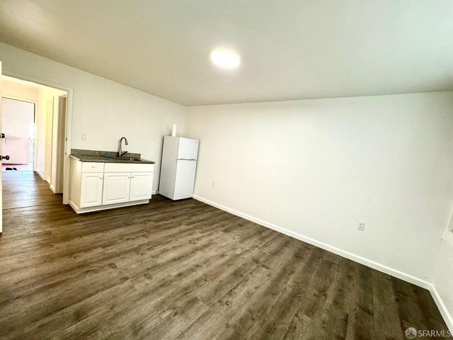 a view of a kitchen with a sink and a refrigerator