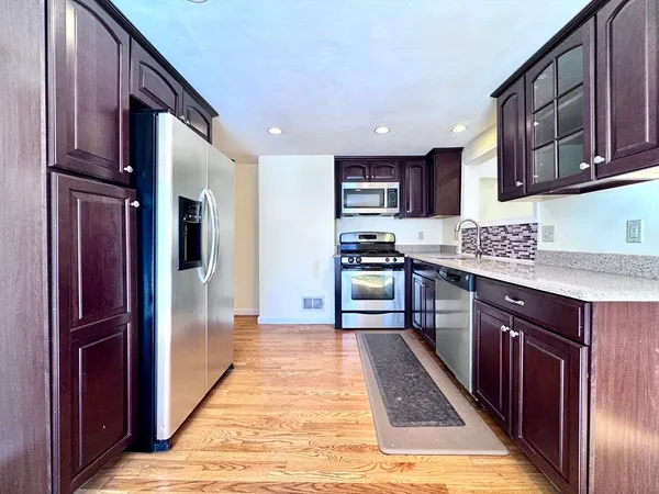 a kitchen with stainless steel appliances granite countertop a refrigerator and a stove top oven