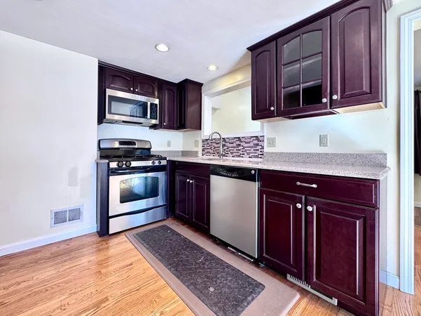 a kitchen with stainless steel appliances granite countertop a stove microwave and sink