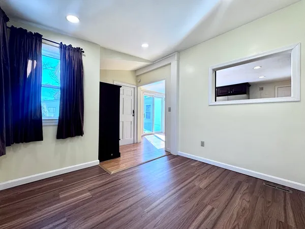 a view of an empty room with wooden floor