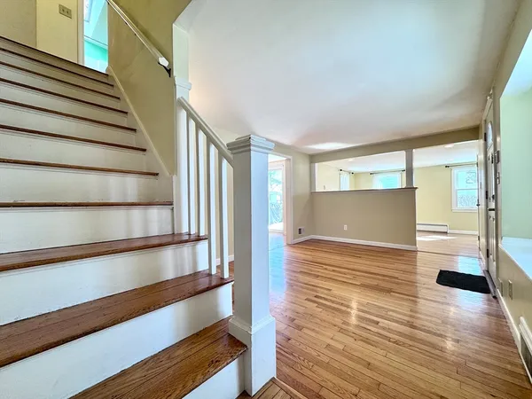 a view of entryway and hall with wooden floor