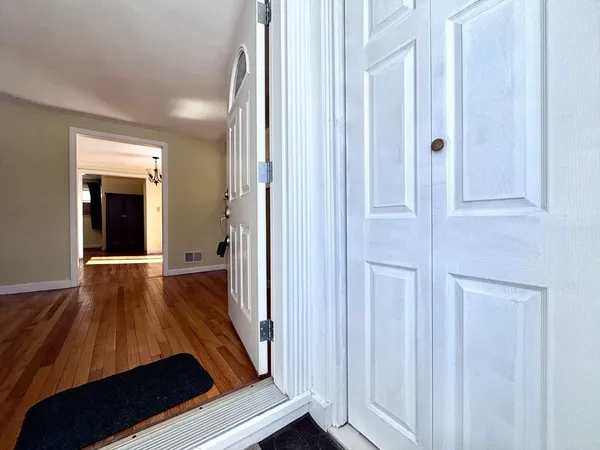 a view of a hallway with wooden floor and staircase