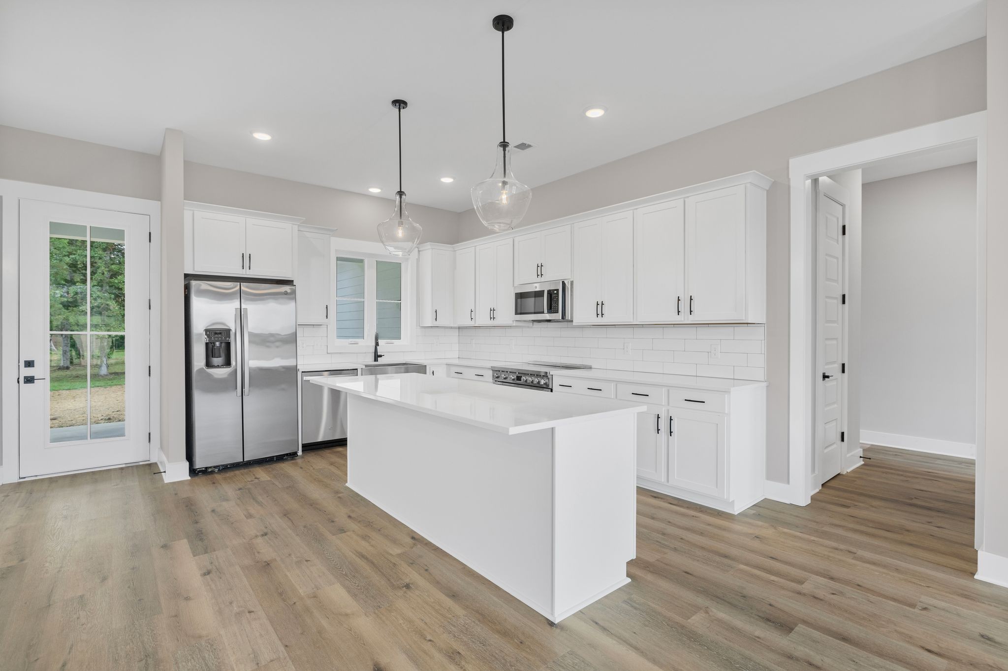 1694 McAfee Road Morrison, TN 37357 - Photo 11 of 41 a large kitchen with stainless steel appliances granite countertop a refrigerator a stove a sink and white cabinets with wooden floor