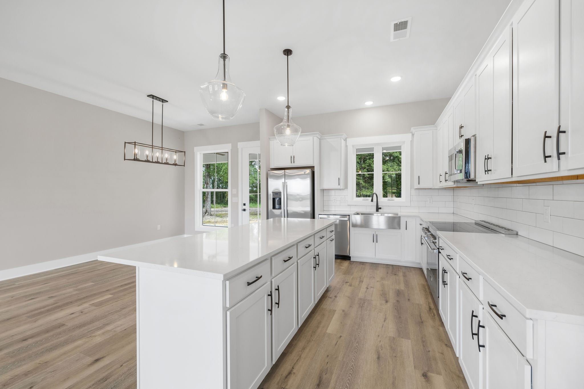 1694 McAfee Road Morrison, TN 37357 - Photo 12 of 41 a large kitchen with kitchen island white cabinets and wooden floor