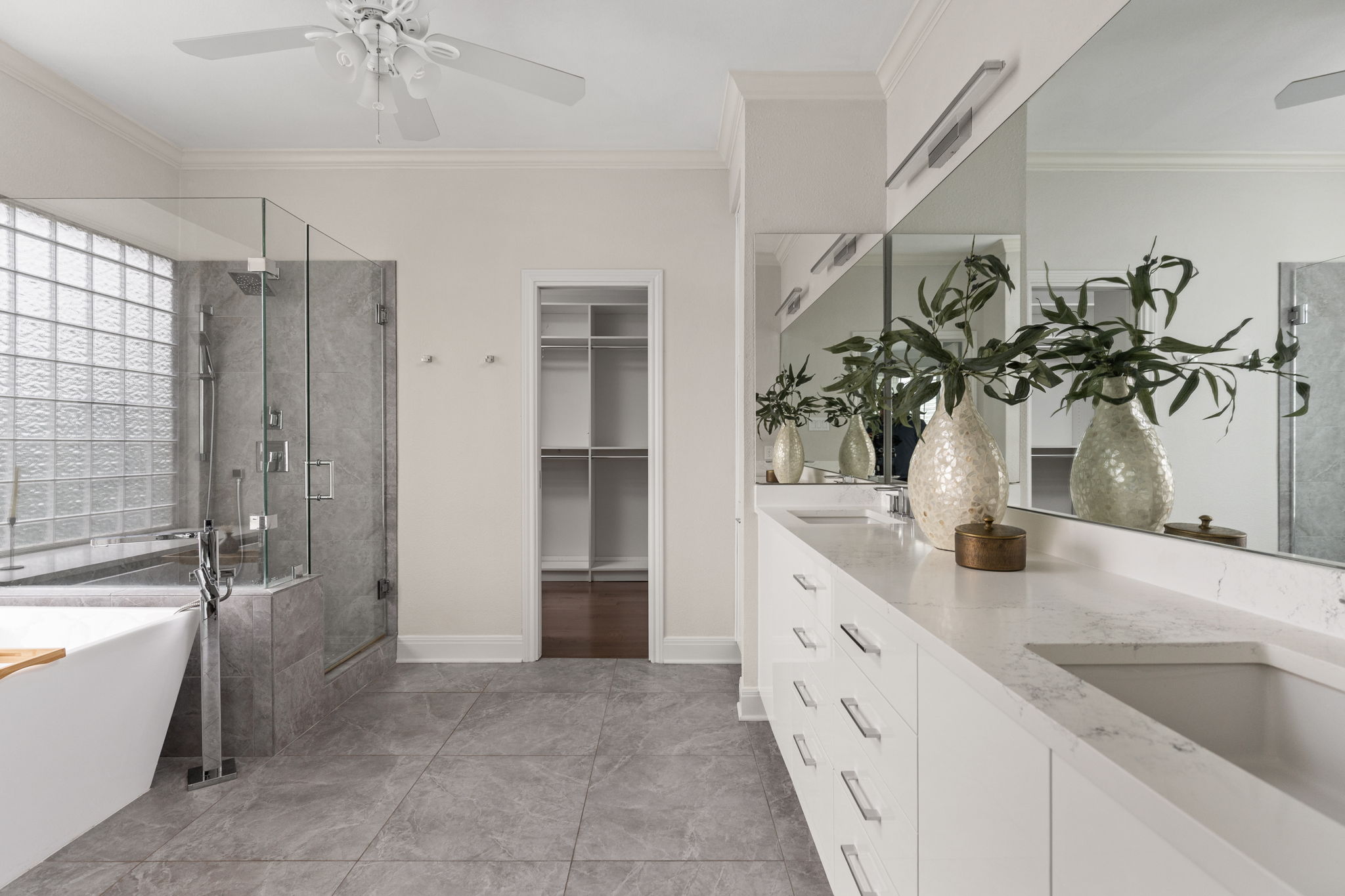 2807 Round Table Road Austin, TX 78746 - Photo 16 of 40 Spacious bathroom featuring a dual vanity with integrated sinks, a large frameless mirror, and overhead linear lighting