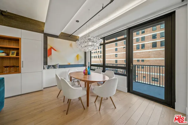 a dining room with furniture large windows and wooden floor