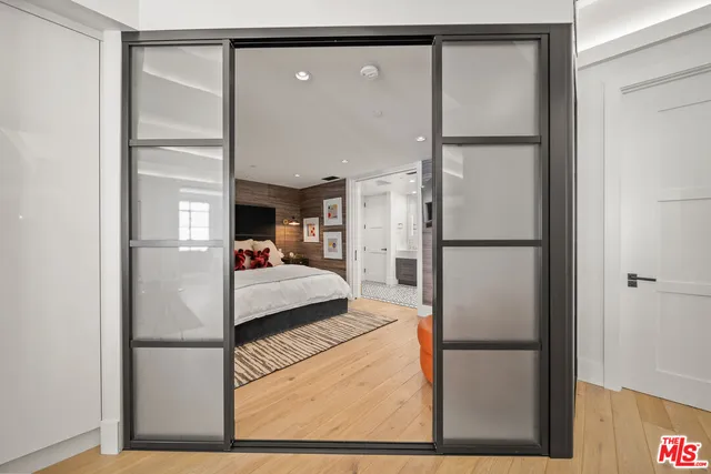 a bedroom with a bed a mirror and a glass door