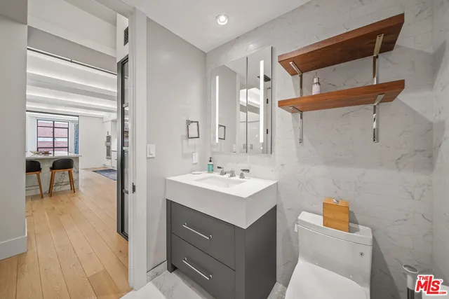 a bathroom with a sink a toilet and a mirror