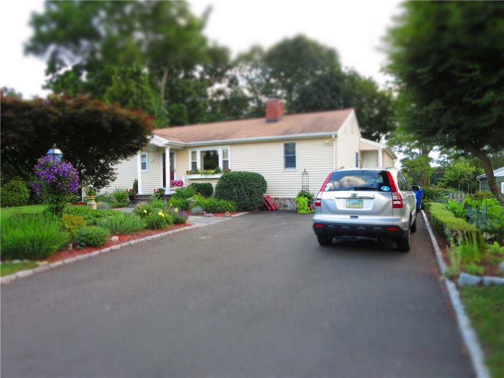 39 Pettom Road Norwalk, CT 06850 - Photo 1 of 1 a car parked in front of a house with potted plants