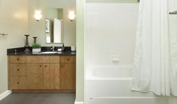 a bathroom with a bathtub a sink a vanity and a mirror