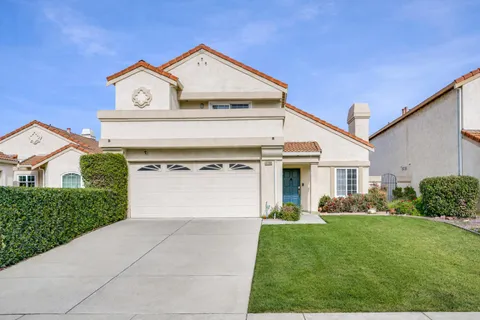 a living room with furniture a rug a fireplace and a window