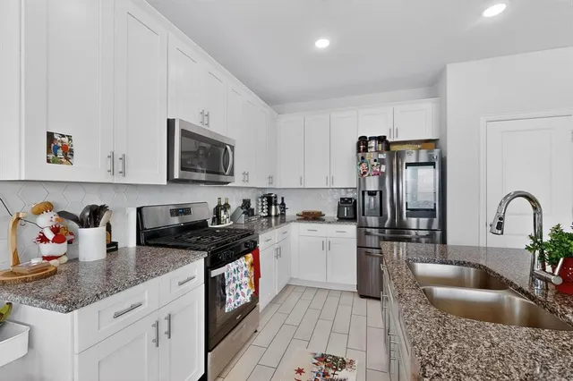 a kitchen with a sink dishwasher a stove and a refrigerator with wooden floor