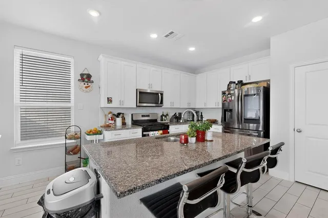 a kitchen with stainless steel appliances granite countertop a sink and stove