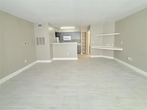 a view of a livingroom with wooden floor and kitchen