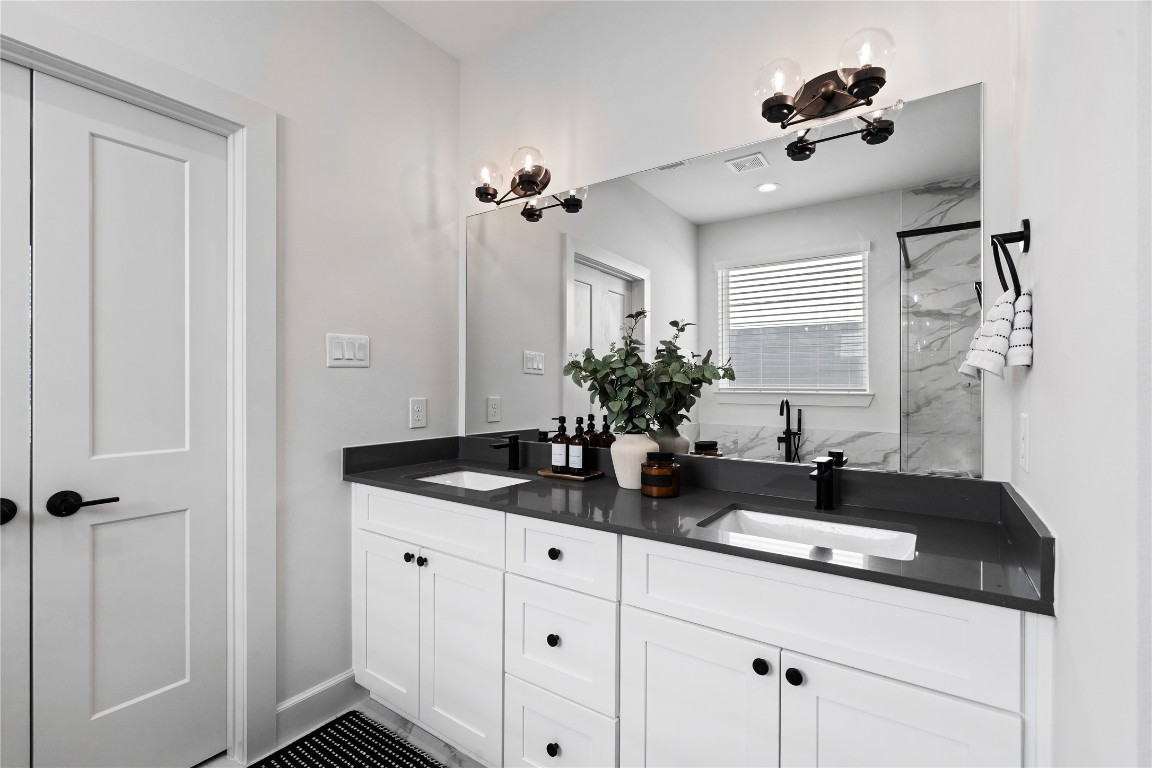 4710 Moving Meadows Houston, TX 77018 - Photo 30 of 42 The double vanity offers separate space on each side, giving both people their own area to get ready without crowding. It’s a practical feature that keeps the bathroom organized and convenient.