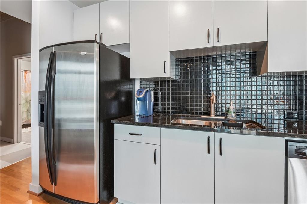 250 Pharr Road Northeast, Unit 701 Atlanta, GA 30305 - Photo 7 of 21 a kitchen with a refrigerator and a sink