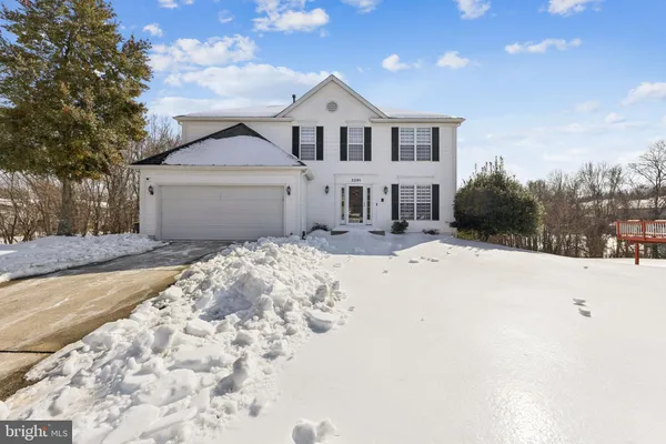 a front view of a house with a yard covered in snow