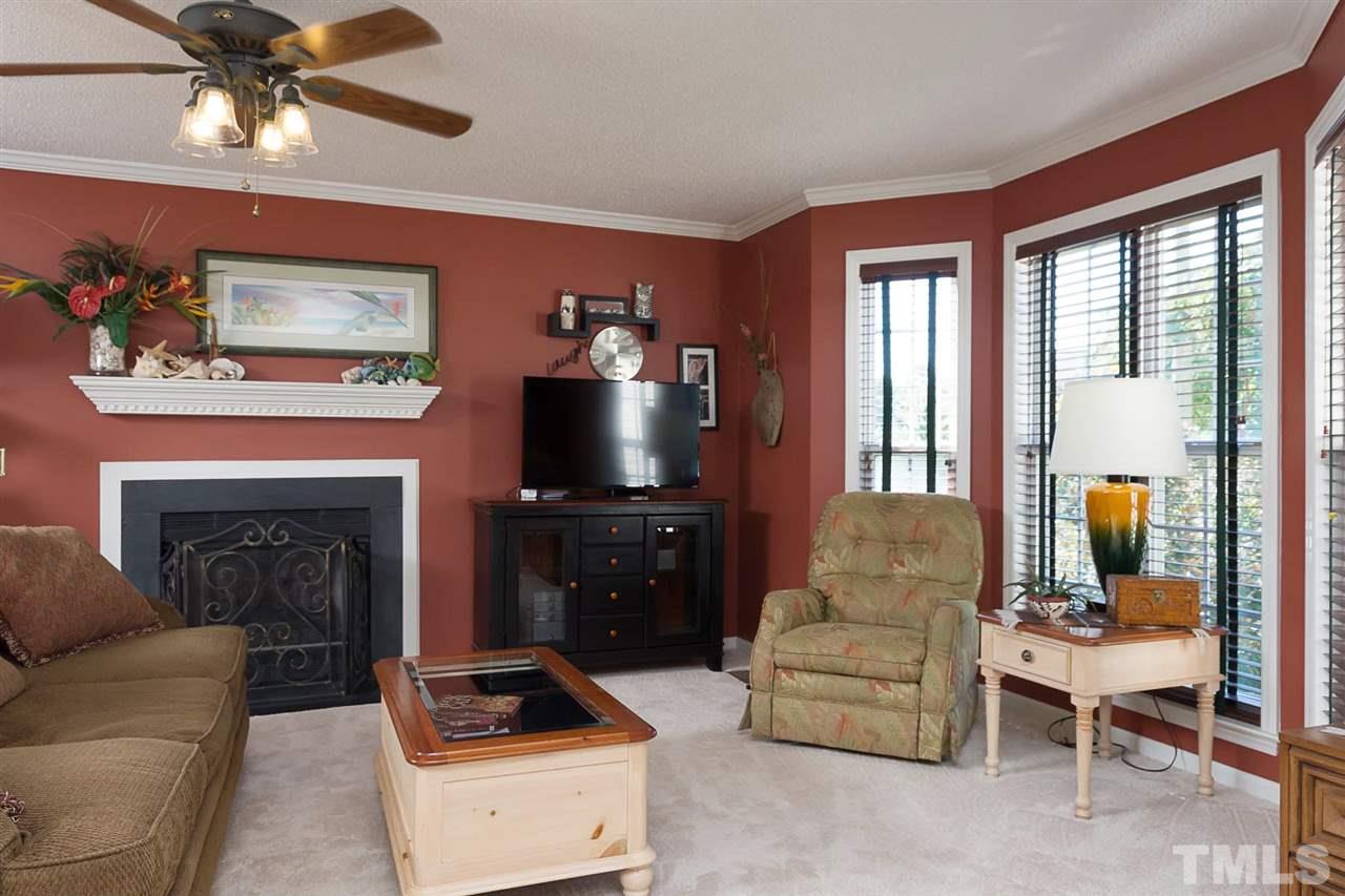 4529 Moss Spring Drive Raleigh, NC 27616 - Photo 3 of 21 a living room with furniture a flat screen tv and a fireplace