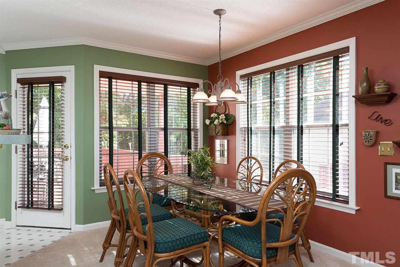 4529 Moss Spring Drive Raleigh, NC 27616 - Photo 6 of 21 a dining room with furniture large windows and a chandelier
