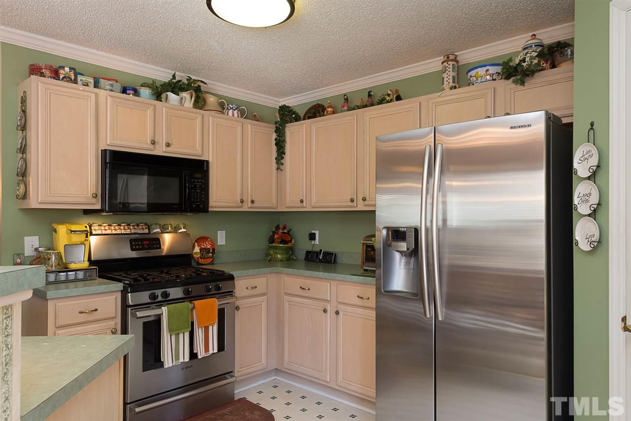 4529 Moss Spring Drive Raleigh, NC 27616 - Photo 8 of 21 a kitchen with a refrigerator and a stove top oven