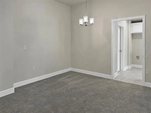 an empty room with chandelier fan