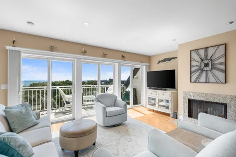 a living room with furniture a flat screen tv and a large window