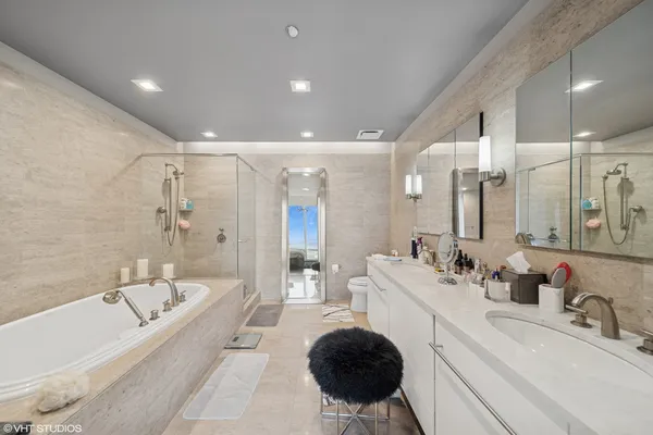 a large bathroom with a tub a sink and a large mirror