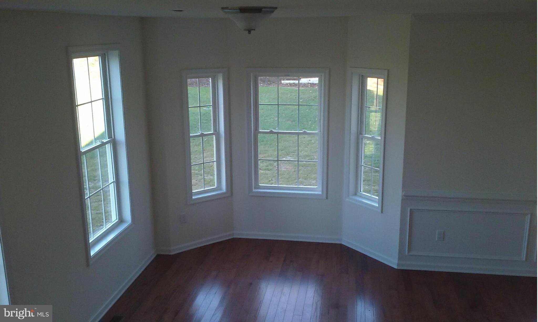 17523 Falls Road Upperco, MD 21155 - Photo 15 of 19 a view of an empty room with wooden floor and a window