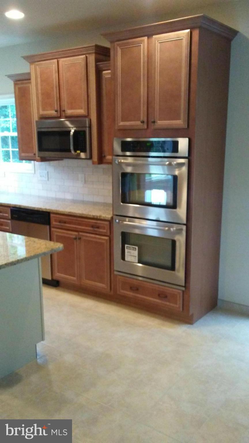 17523 Falls Road Upperco, MD 21155 - Photo 17 of 19 a kitchen with granite countertop a stove and a microwave