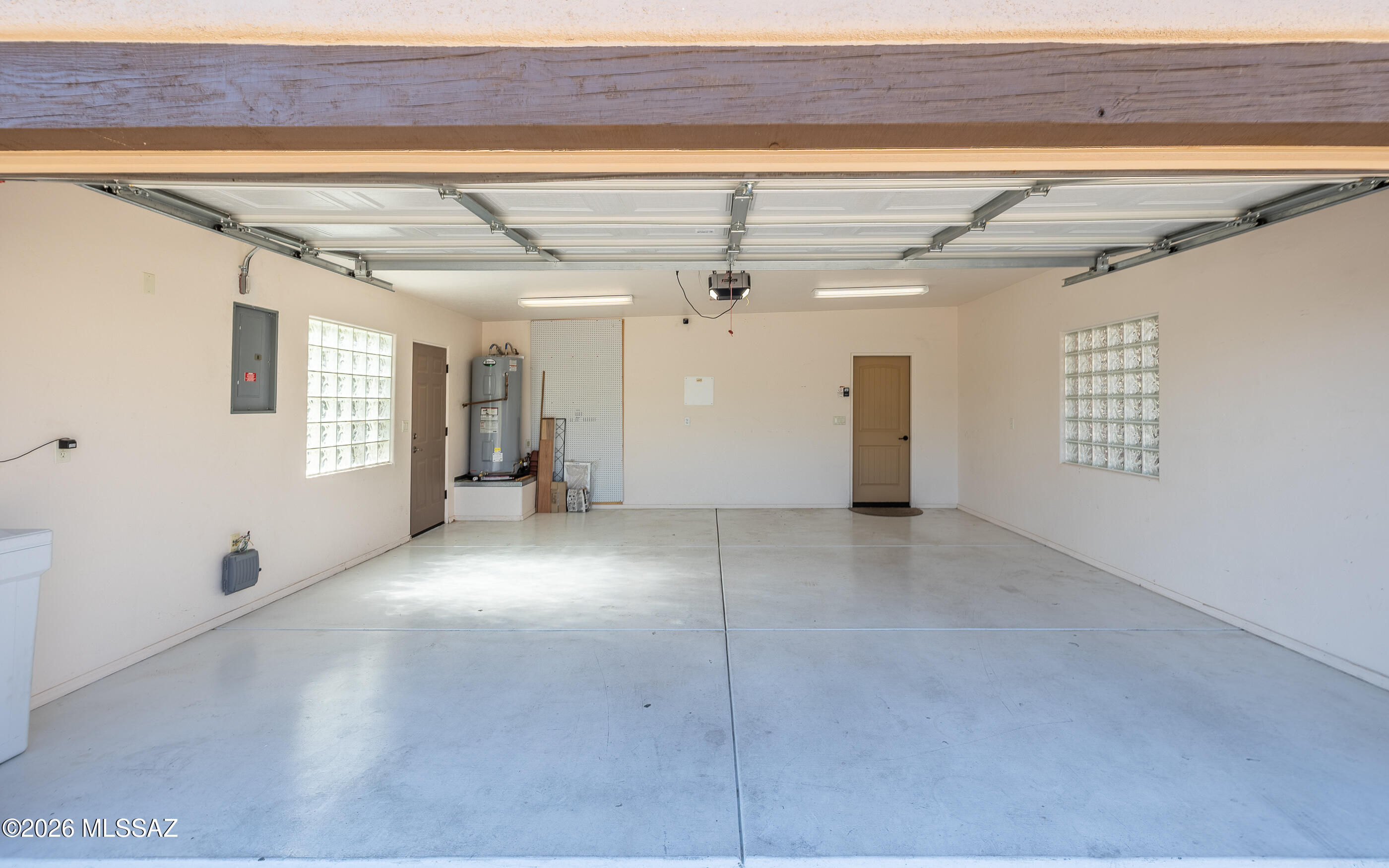 5550 West Open R Place Tucson, AZ 85713 - Photo 44 of 48 Spacious two-car garage with side door access to the exterior, and privacy-enhancing glass block windows that allow natural light to filter in while maintaining security!