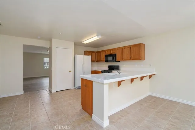 a view of kitchen with stainless steel appliances cabinets and stove top oven