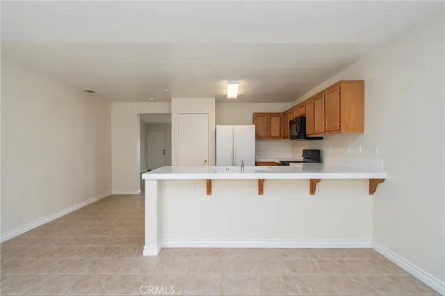 a view of kitchen with stainless steel appliances granite countertop refrigerator sink and stove
