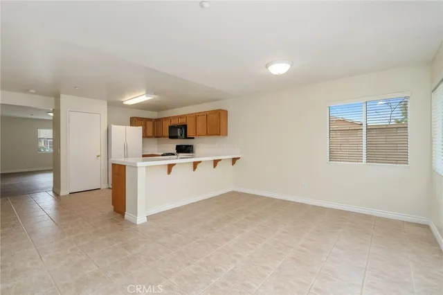 a view of kitchen with wooden cabinet and refrigerator