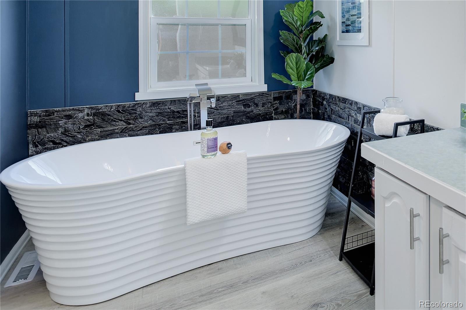 5115 West Custer Place Denver, CO 80219 - Photo 15 of 25 a white bath tub sitting in a bathroom