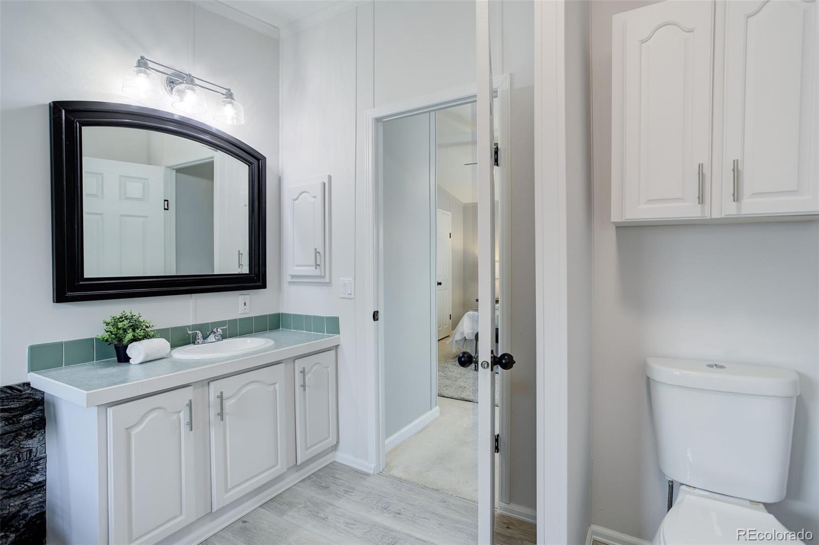 5115 West Custer Place Denver, CO 80219 - Photo 17 of 25 a bathroom with a toilet sink and mirror