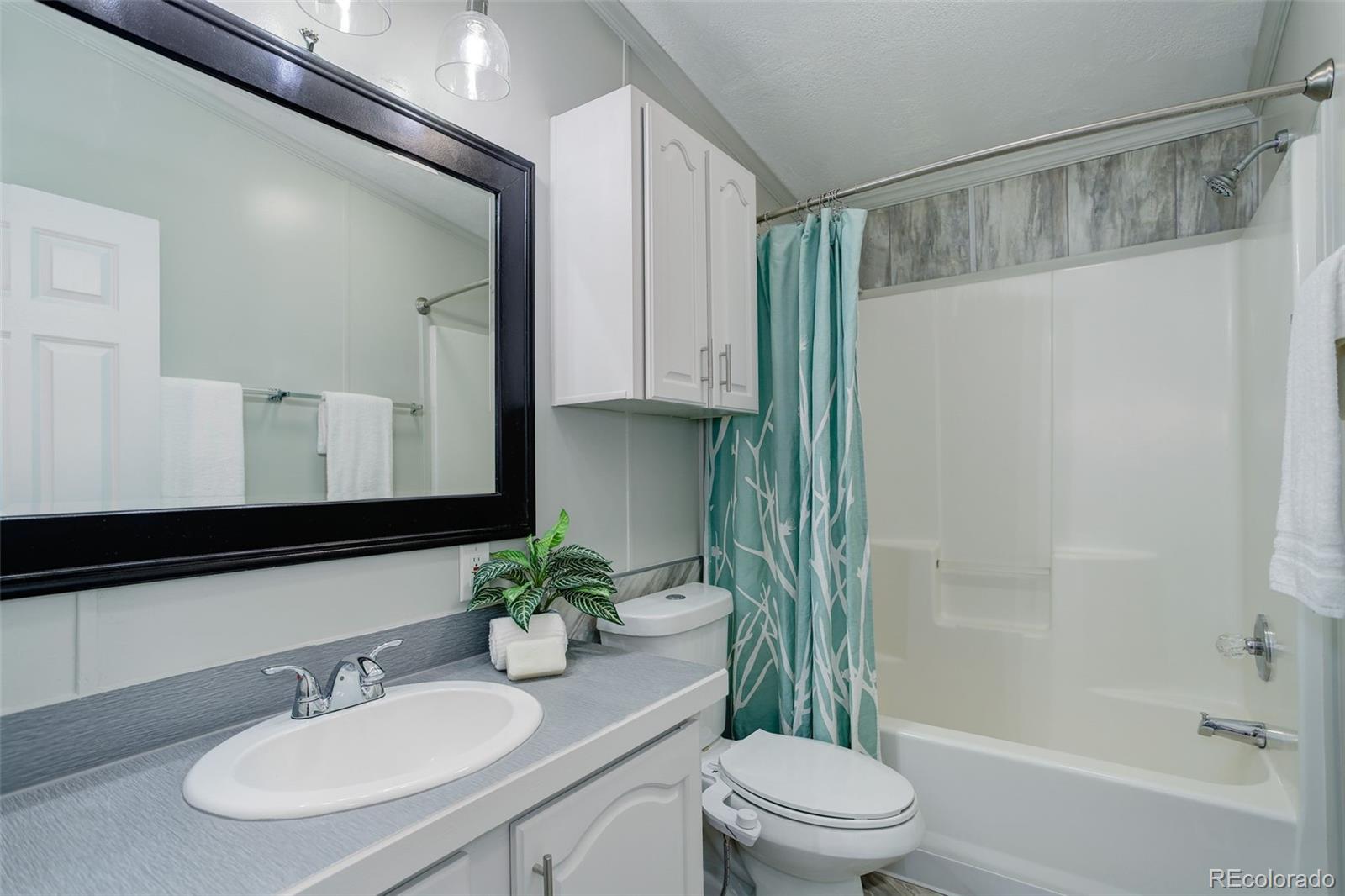 5115 West Custer Place Denver, CO 80219 - Photo 19 of 25 a bathroom with a granite countertop sink a toilet and shower