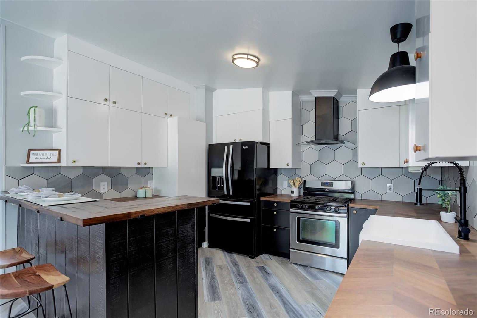5115 West Custer Place Denver, CO 80219 - Photo 6 of 25 a kitchen with a sink a counter space and stainless steel appliances
