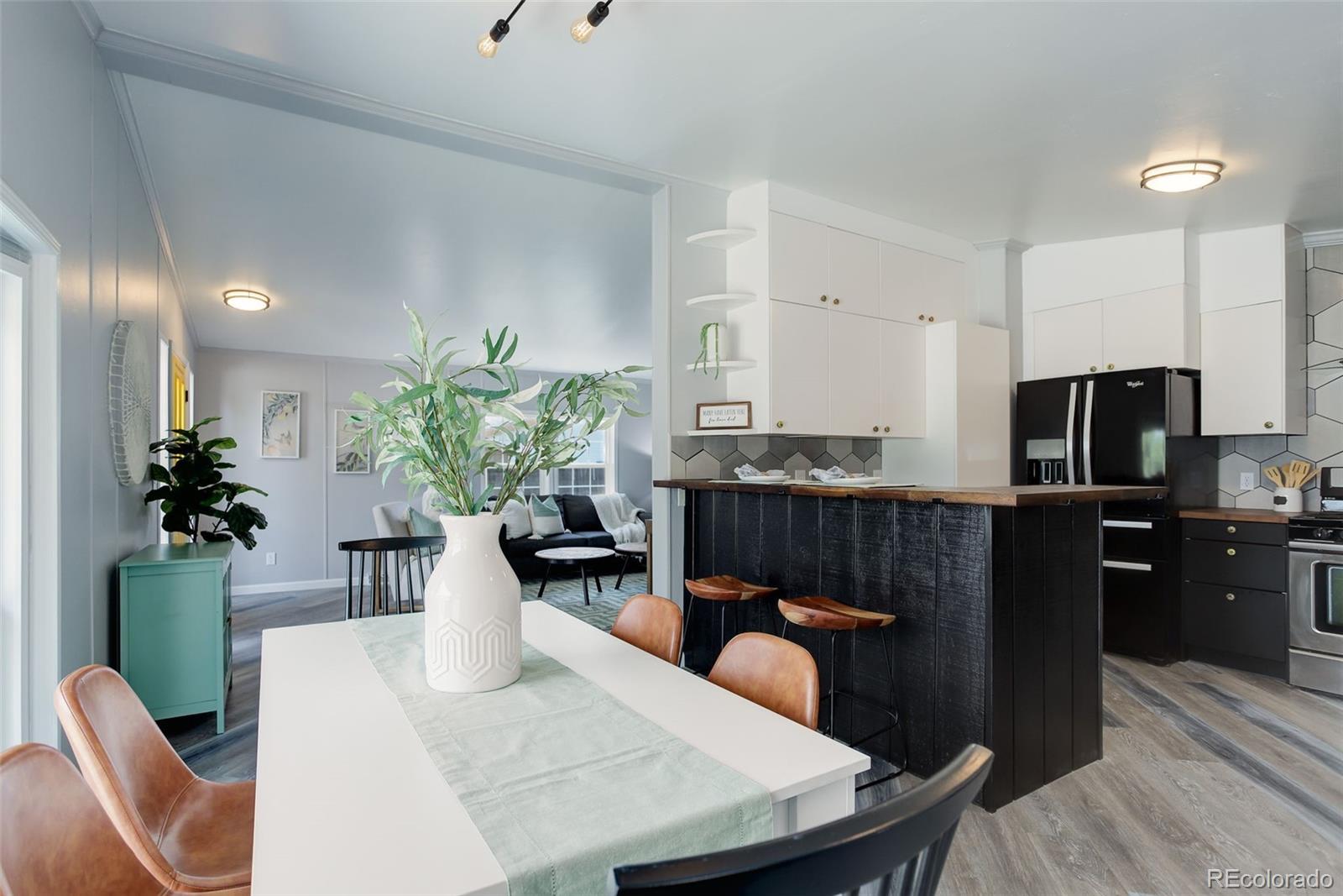 5115 West Custer Place Denver, CO 80219 - Photo 10 of 25 a kitchen with stainless steel appliances granite countertop a table chairs in it and wooden floor