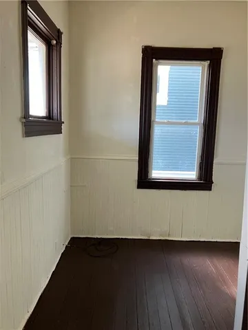 a view of a small space with wooden floor and a window